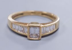 Am 18ct gold and diamond dress ring, with central octagonal cut stone and emerald cut shoulders,