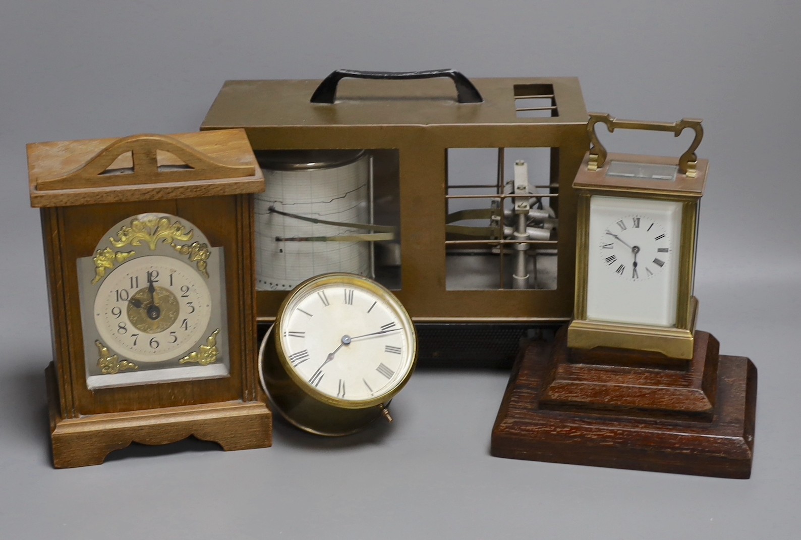 A barograph and three various time pieces including a carriage timepiece, a walnut bracket timepiece