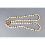 A two strand cultured pearl necklace, with white opal set 14ct gold clasp, 35cm