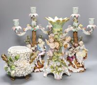A pair of continental porcelain figural candlesticks and a similar candelabra base, together with