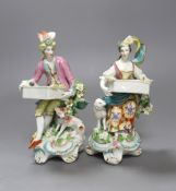 Two Derby sweetmeat figures, each seated and resting with an open rectangular basket on their knees,