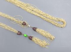 An Indian multi-strand seed pearl sautoir necklace, with ruby set white metal terminals, length