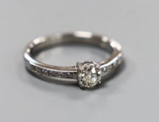 A modern platinum and single stone diamond ring, with diamond set shoulders, size M, gross weight