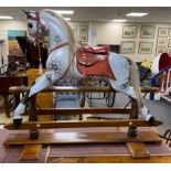 A Stevenson Brothers carved wood dapple grey rocking horse, with burgundy leather tack on beech