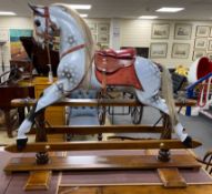 A Stevenson Brothers carved wood dapple grey rocking horse, with burgundy leather tack on beech