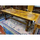 An 18th century style rectangular pale oak refectory dining table with central stretcher and two