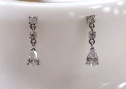 A modern pair of 750 white metal, pear and round cut diamond set drop earrings, 18mm, gross weight