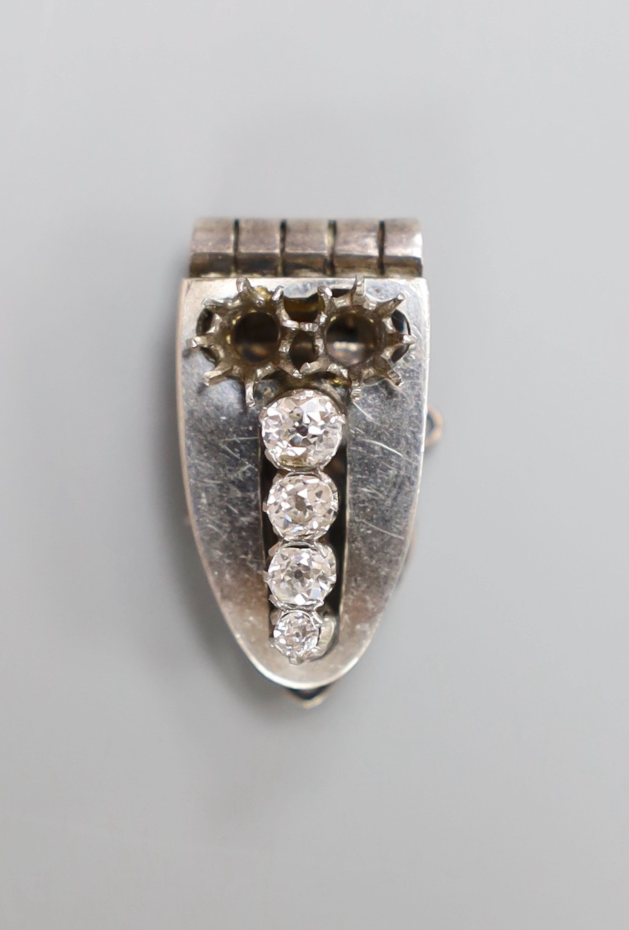 A white metal (stamped sterling silver) and graduated four stone diamond set clip brooch, 27mm, with