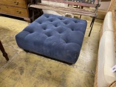 A contemporary buttoned blue fabric footstool
