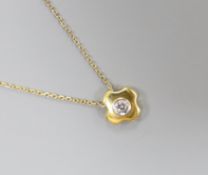 A modern 18ct gold and single stone diamond set quatrefoil pendant, 7mm, on an 18ct gold fine link