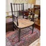 A Victorian ebonised Morris style Sussex chair with rush seat, width 58cm, depth 47cm, height 87cm