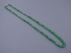 A graduated jade bead necklace with diamond set clasp stamped 9ct, 50cm