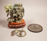 A Chinese bronze mirror, 11cm diameter, a jadeite floral carving on stand with a metal relief