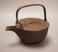 A Japanese cast iron and bronze teapot on tripod stand, inscribed, 19cm wide including spout