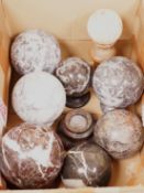 A quantity of carved marble balls on stands