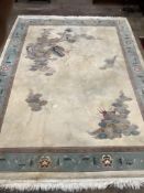 A Chinese gold ground carpet woven with dragon and flaming pearl motif within a geometric floral