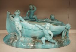 A large Continental majolica centrepiece with cherub figures and boat, 56cm