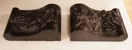 A pair of carved black marble corbels, fruiting vines, 24x17cm