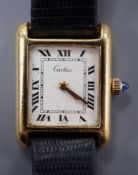 A ladies gold plated Cartier tank wrist watch, with cabochon set winder