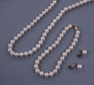 A single strand cultured pearl necklace with matching bracelet and drop earrings