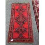 An Afghan red ground rug, 184 x 90cm