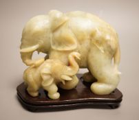 A Chinese carved bowenite ‘elephant’ group on hardwood stand, 15cm