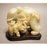 A Chinese carved bowenite ‘elephant’ group on hardwood stand, 15cm