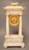 A 19th century alabaster portico clock with a gilt metal prowling lion decoration, 50cm tall