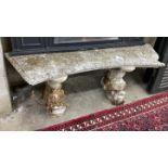 A reconstituted stone curved garden seat on dolphin supports, length 144cm, depth 33cm, height 49cm