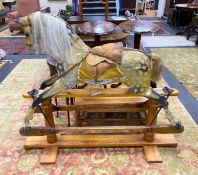 An early 20th century Ayers type dapple rocking horse with tan leather tack on pine safety frame,