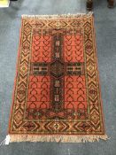A Belouch style red ground rug, 130cm x 84cm