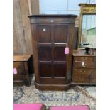 An 18th century style oak standing corner cupboard, enclosed by a full length door, width 94cm,