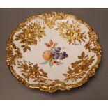 An early 20th century century Meissen fruit and floral gilt motif dish, 30cm diameter