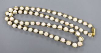 A modern 18ct gold and graduated white coral bead set single strand necklace, with 18ct gold