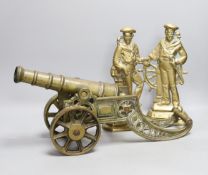 A cast bronze model of a cannon and a pair of cast brass sailors, cannon length 45cm