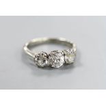 An 18ct, plat and three stone diamond ring, size K, gross weight 2.9 grams, the central stone