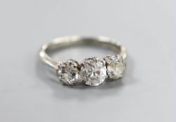 An 18ct, plat and three stone diamond ring, size K, gross weight 2.9 grams, the central stone