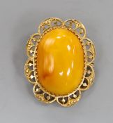 A 22ct mounted oval amber set brooch, 44mm, gross weight 12.1 grams.