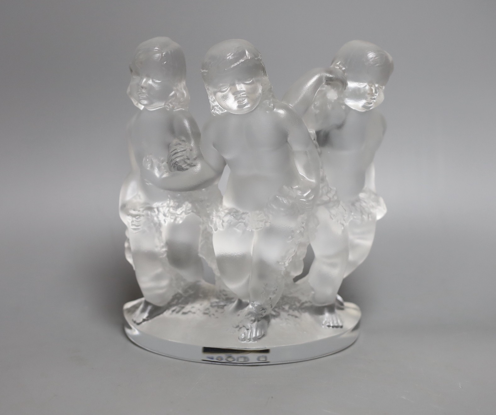 A Lalique glass model of three putti, boxed,18 cms wide,