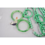 A group of three jadeite necklaces, together with two jadeite bracelets, two green glass bangles and