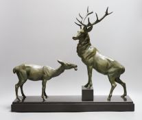 A French bronzed metal model of a stag and deer on a black marble base, signed L. Carvin,43 cms