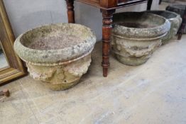 A pair of circular reconstituted stone garden urns with swagged floral bodies diameter 46cm height