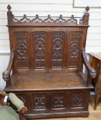 An early 20th century Gothic style carved oak box seat settle, length 116cm, depth 45cm, height