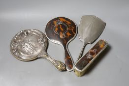 A George V silver and tortoiseshell mounted hand mirror and clothes brush, one other silver