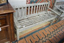 A near pair of weathered slatted teak garden benches, larger length 155cm, depth 56cm, height 90cm
