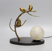 A French 1930's bronze lamp of stylistic birds in a tree, with a frosted globe shade on a black