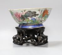A Chinese Tongzhi famille rose dish with floral and bird decoration on carved stand, 14cm tall