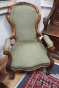 A Victorian walnut spoon back open armchair