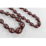 A single strand graduated oval simulated cherry amber bead necklace, 94cm, gross weight 100 grams.