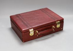 A small red leather mounted suitcase